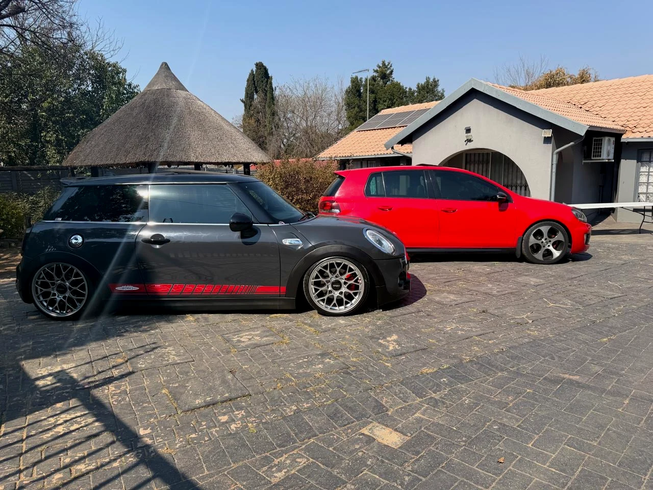 Modified dark Mini and red Volkswagen Golf parked together